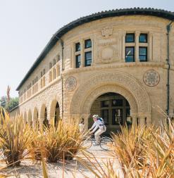 A bicyclist zooms by Memorial Quad, past the Language corner.